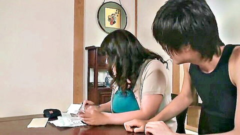 Mature Asian woman writing at table with young man looking over, girlfriend's mom JAV scene