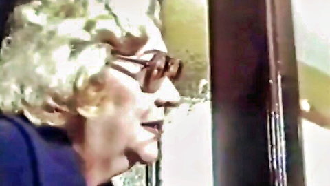 Vintage 1986 granny with blonde curls and glasses in seductive profile
