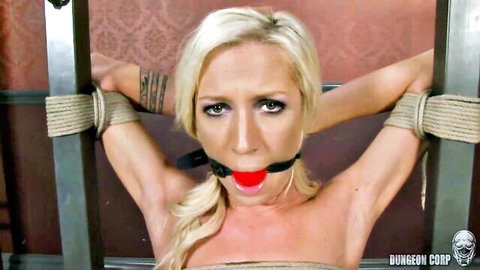 Blonde woman bound with ropes and ball gag for BDSM vibrator session