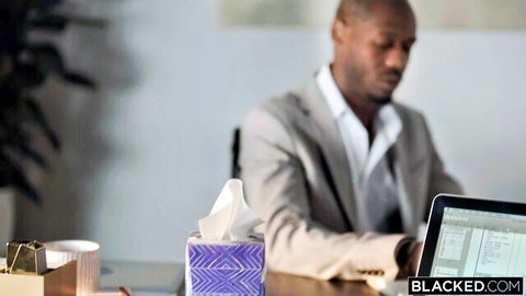 Handsome suited black man working at office desk in Blacked interracial scene
