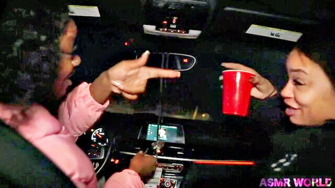 Two sexy ebony women laughing in car holding red cups making finger gun gesture ASMR