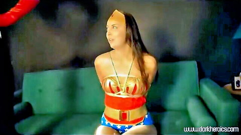 Bound Wonder Woman cosplay babe with massive tits tied on couch teasing pussy