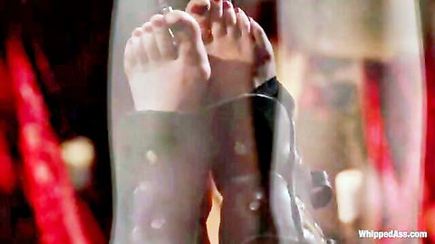 Bare pale feet soles with red painted toes pressed against steamy glass in BDSM femdom scene