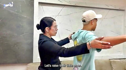 Brunette secretary in suit lifts young man's arms playfully from behind in office