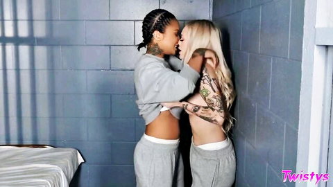 Interracial lesbian embrace in prison, topless blonde and tattooed ebony in sweats
