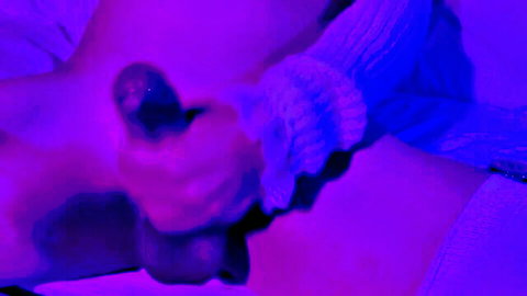 Hand gripping thick veiny erect cock with balls visible under purple neon lights