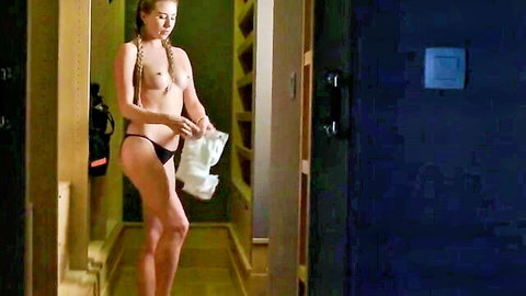 Topless blonde babe with pigtails and perky tits holds towel flaunting big ass in black thong in locker room