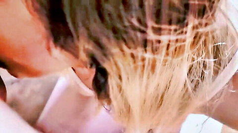 Blonde woman with tousled hair in pink top, ecstatic side profile close-up