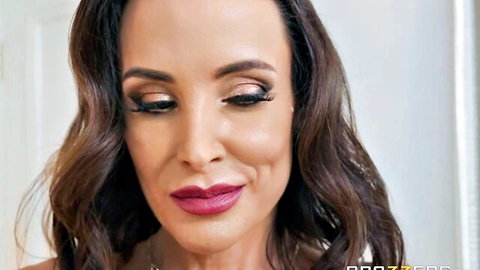 Lisa Ann sultry close-up with wavy brunette hair and bold makeup, Brazzers MILF thumbnail