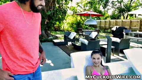 Reyna Delacruz in pink bikini smiles at muscular man by pool in cuckold tease