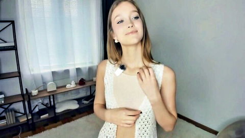 Blonde teen smiles exposing perky tits through open white crochet top in webcam solo