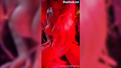 BigTittyGothEgg in red latex goth outfit, big tits side profile
