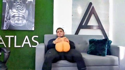 Muscular Latino guy squeezing massive orange bubble butts between his legs on couch