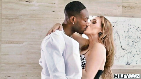 Curvy blonde MILF with big tits passionately kissing black stud in polka dot dress