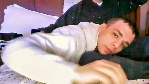 Two hot tattooed Latino gay guys cuddling intimately in bed