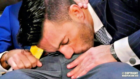Suited stud giving intense oral to huge dick in gay scene