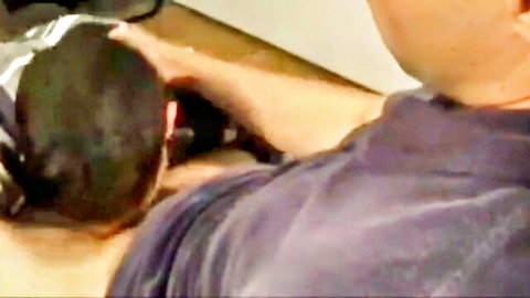 Man bent over table as friend approaches from behind in gay encounter