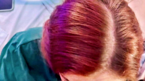 Purple-haired stepsister in green scrubs, close-up view