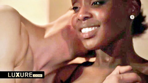 Two sexy ebony women smiling intimately close-up with faces touching teasingly