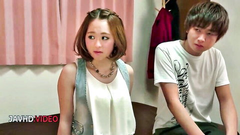 Cute Japanese girl in tight white tank top stares at young Asian guy in t-shirt on bed JAV