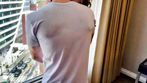 Hotwife in gray t-shirt by city window, teasing threesome latex scene