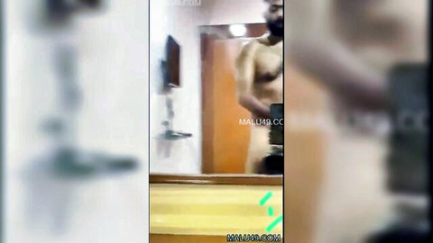 Blurry amateur South Asian man stands shirtless in bathroom stroking cock