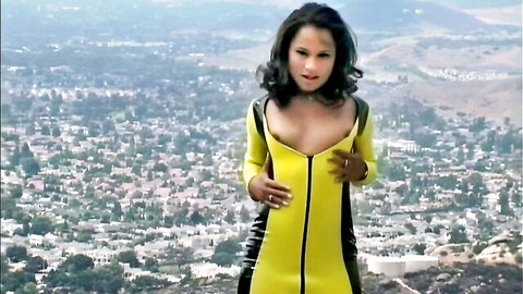 Sabina Star in shiny yellow latex catsuit, teasing cleavage over cityscape