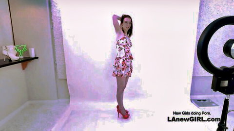 Exciting new model in floral mini dress poses seductively in studio
