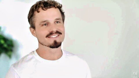 Handsome curly-haired guy smiling in threesome with two cute girls sharing big cock