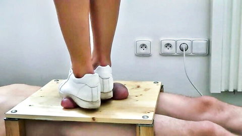 Woman's white sneakers crushing naked man's swollen purple balls on wooden box in CBT trampling