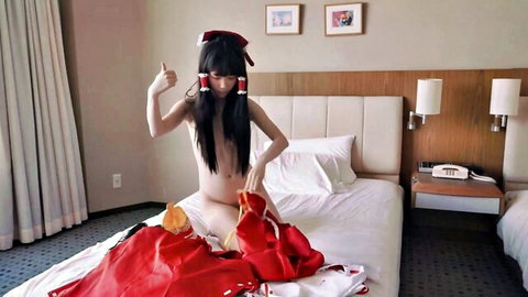 Nude Japanese woman with red hair bows posing thumbs up on bed