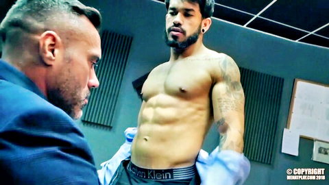 Gloved mature daddy in suit examines muscular tattooed hunk's ripped abs and Calvin Klein briefs