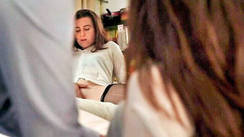 Brunette in unbuttoned white shirt and black stockings sits teasingly with exposed midriff and aroused expression