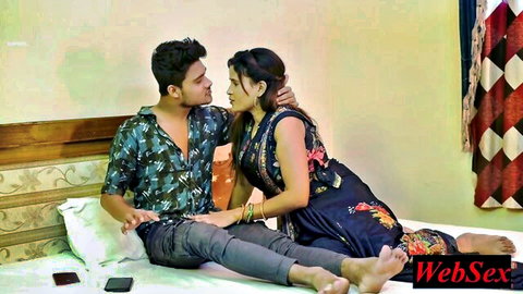 Sexy Indian babe in black top and skirt intimately cuddling with guy on bed teasing foreplay