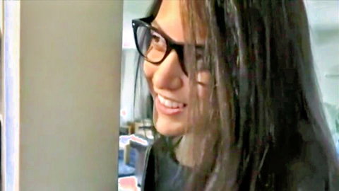 Sexy Asian babe in black glasses smiling passionately teasing viewers