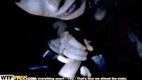 Blurry close-up of pale woman in white top at dark disco party, hands on body