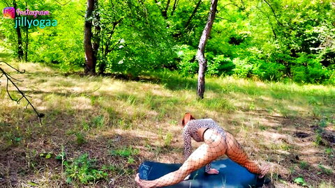 Flexible redhead in leopard print thong leotard doing yoga splits outdoors