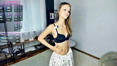 Petite teen webcam girl posing seductively in black bra and low-rise pajama pants