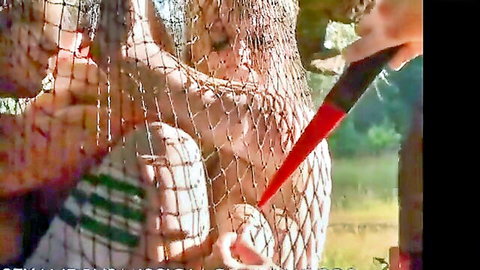Blonde woman bound in fishnet outdoors gets red dildo shoved deep in her ass