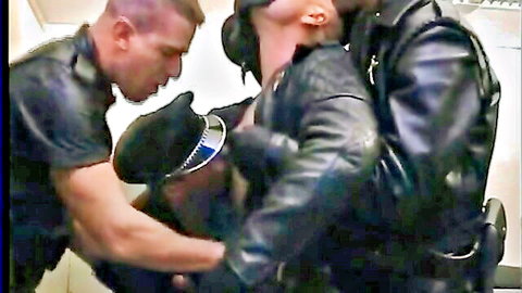 Two muscular men in leather police gear in intense BDSM encounter