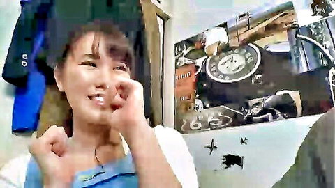 Cute Asian schoolgirl in graduation cap teases with finger gesture on cheek smiling playfully
