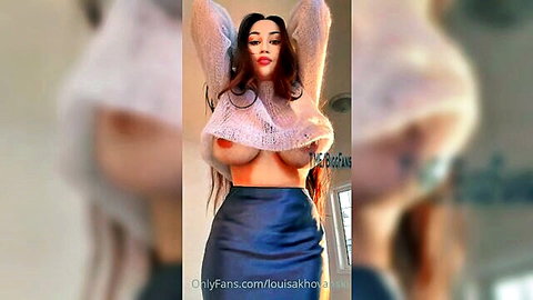 Louisa Khov posing seductively in sheer top exposing large breasts