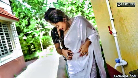 Hot Indian brunette babe in sheer wet white saree embraced by man from behind outdoors
