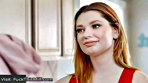 Busty redhead Annabel Redd smiling seductively in red top
