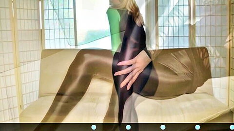 Blonde babe in shiny green bodysuit and sheer stockings spreads legs wide teasing on couch