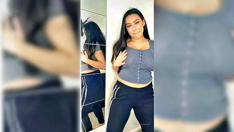 Sexy Leah in gray crop top and black pants, teasing striptease mirror pose