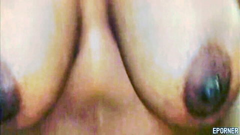 Black nurse's large breasts with dark nipples close-up