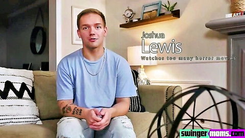 Joshua Lewis sits casually on couch in blue shirt with horror movie watch text overlay