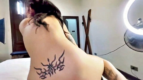 Tattooed Latina babe posing nude from behind, big ass and curves