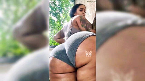 Thick ebony babe with massive ass and butterfly tattoo bends over in tight gray shorts